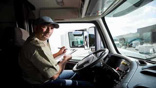 Chauffeur routier remplissant une CMR sur la route