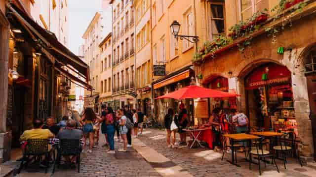 Une rue pavée de Lyon bondée de touristes au cœur du Vieux Lyon.