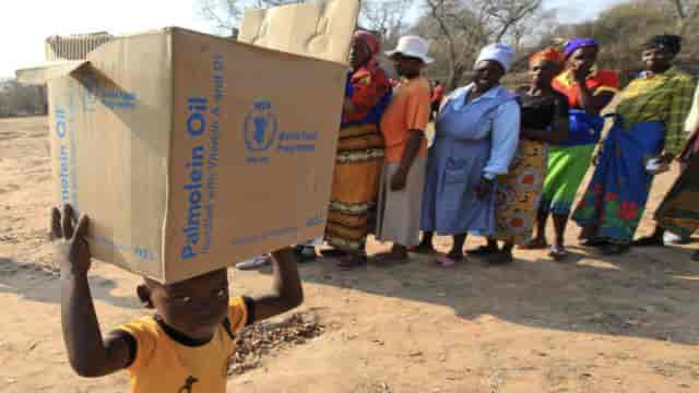 Un enfant porte un carton de rations distribué par le PAM, dans le district de Mwenezi, au Zimbabwe, le 9 septembre 2015.