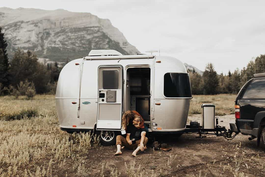 Woman kissing man in silver trailer