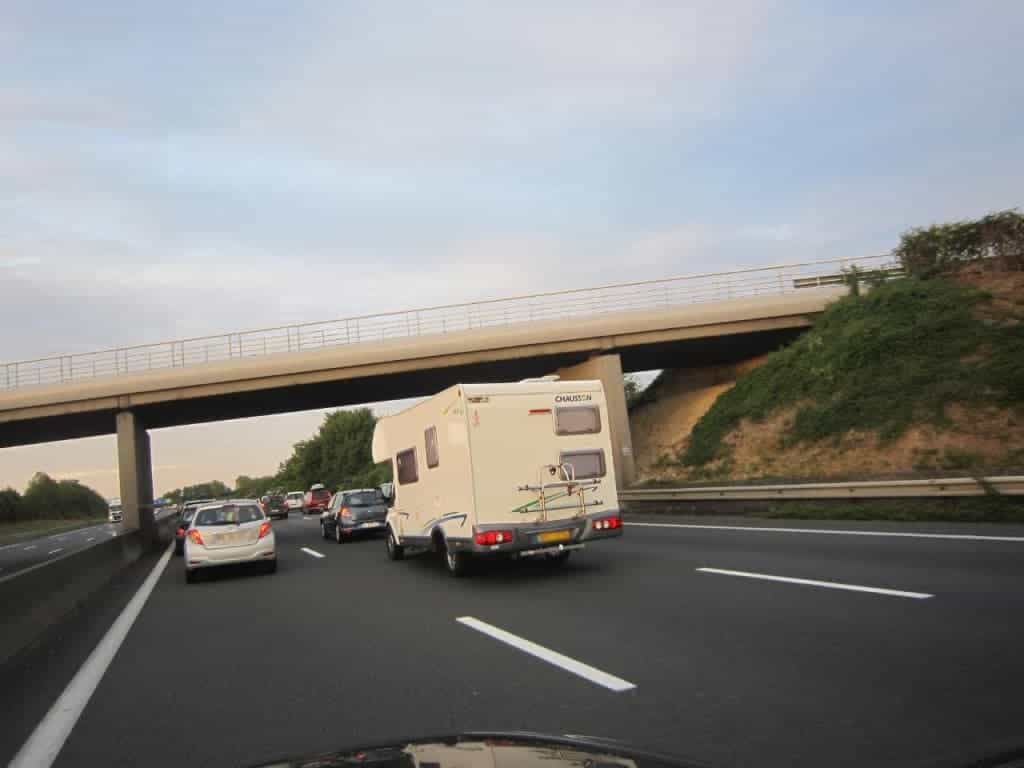 Camping-car tractant un bateau sur l'autoroute