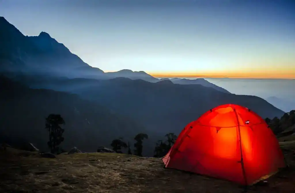 red tent at sunset overlooking water