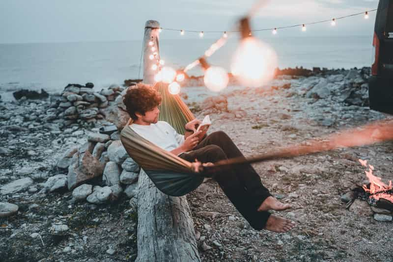 Man reading in a hammock on motorhome campsite