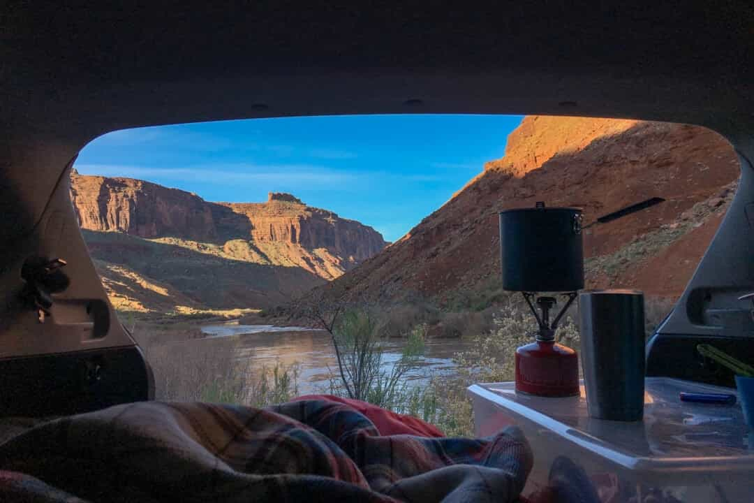 Une vue de roches rouges et d'eau depuis l'arrière d'un hayon ouvert