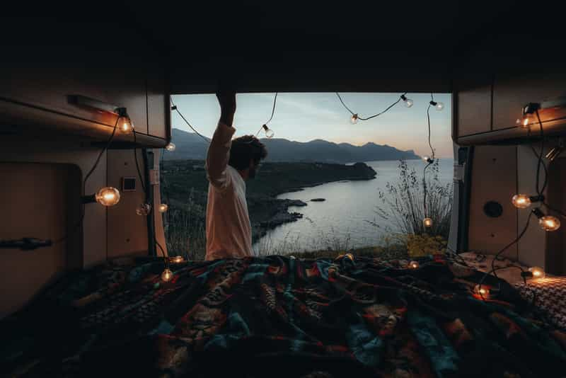 Man enjoying beautiful view from campervan on Sardinia