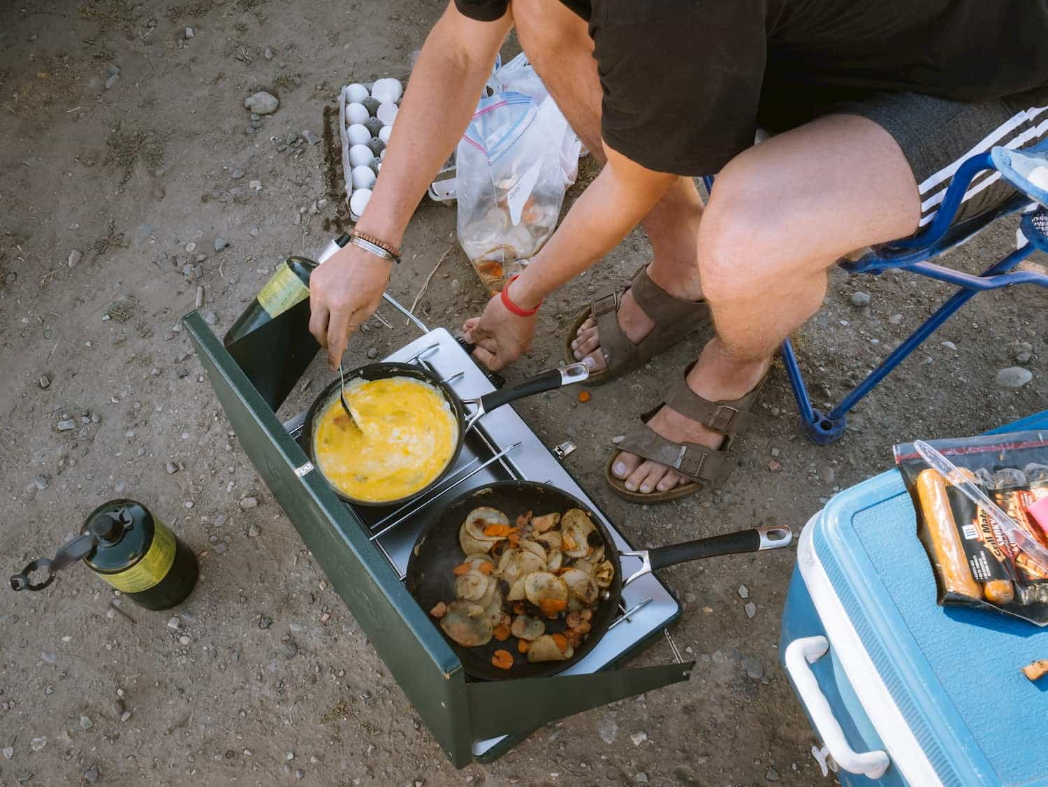 Camper cooking breakfast on a 2 burner stove.