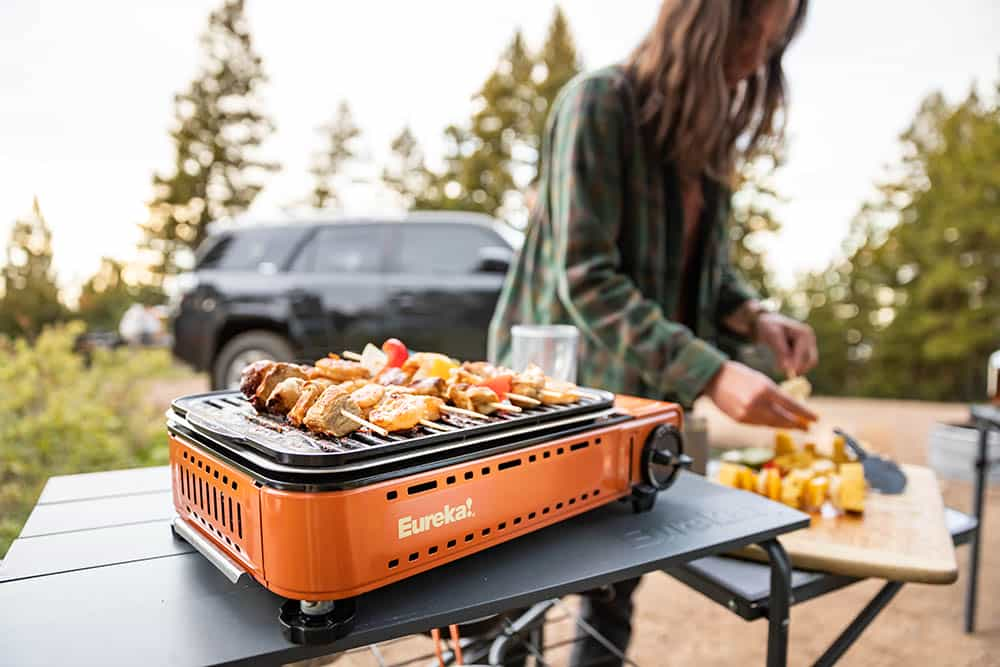 Une femme fait griller des légumes sur un gril Eureka SPRK