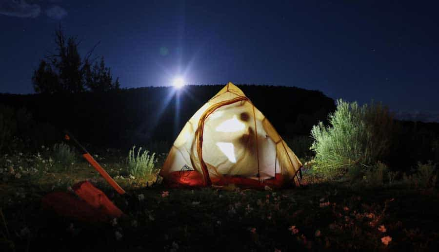 Vue d'une tente avec des lumières la nuit dans la Réserve Nationale de Wilderness de la Forêt Pétrifiée