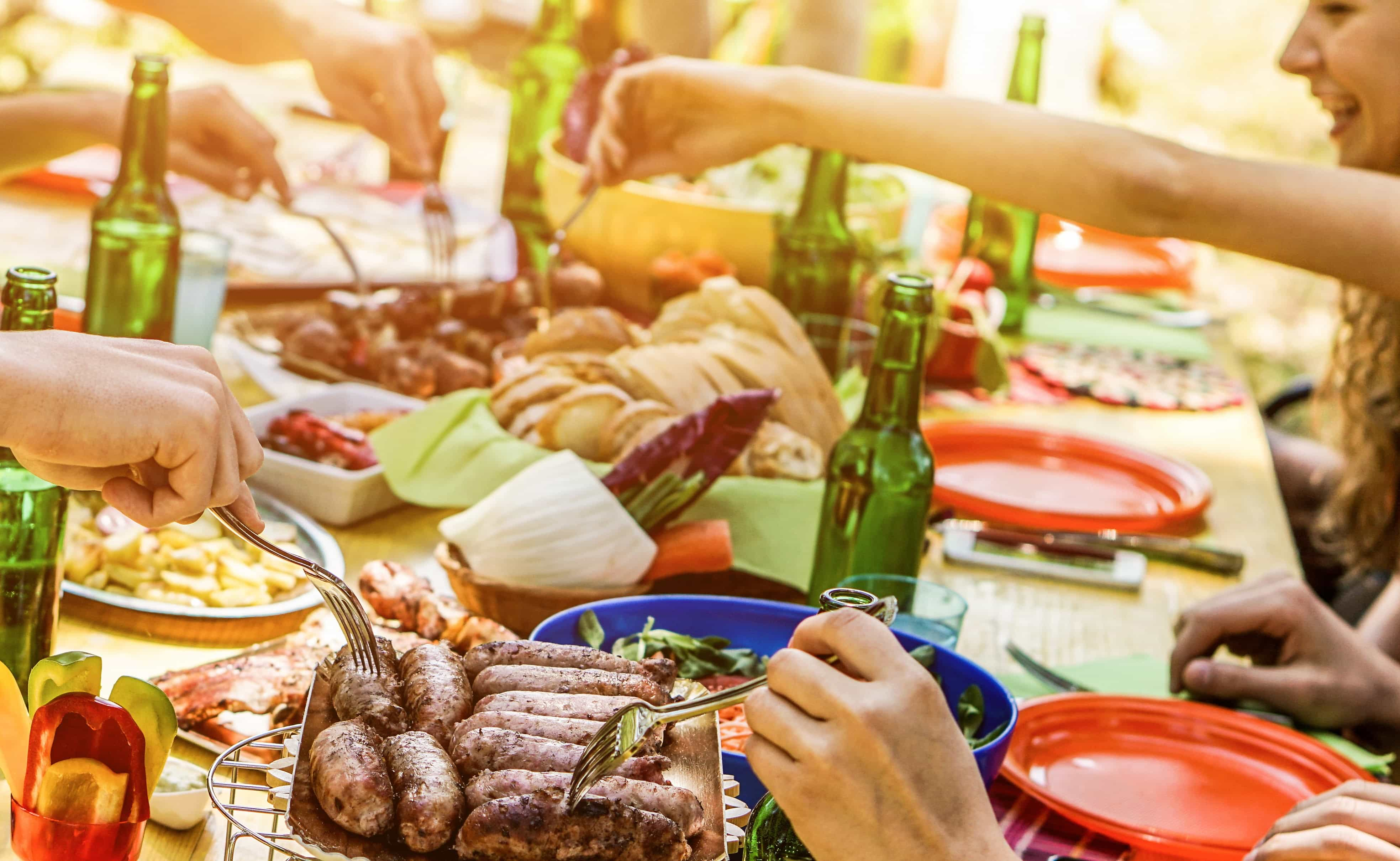 Friends gather around the table for a camping dinner.