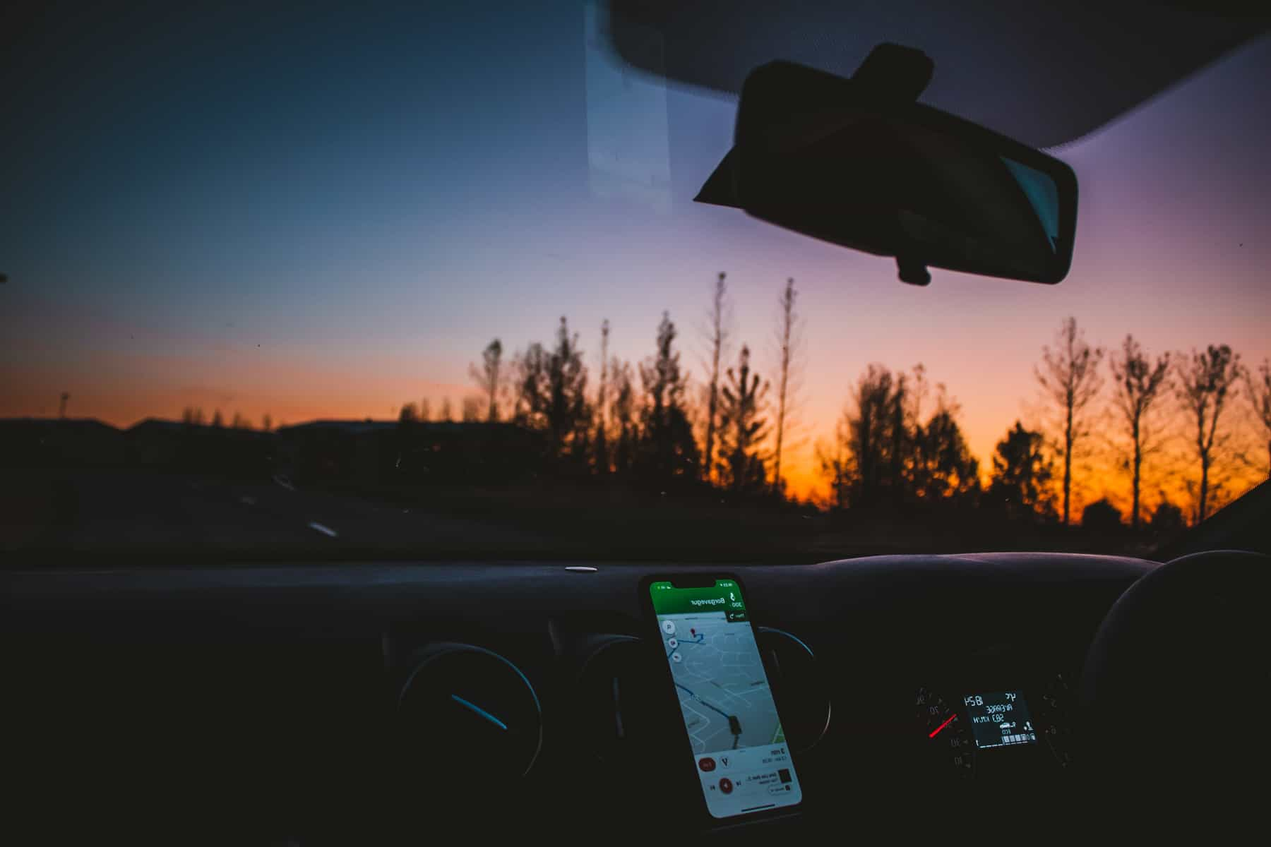 Intérieur d'une voiture avec utilisation de Google Maps pour la navigation au coucher du soleil