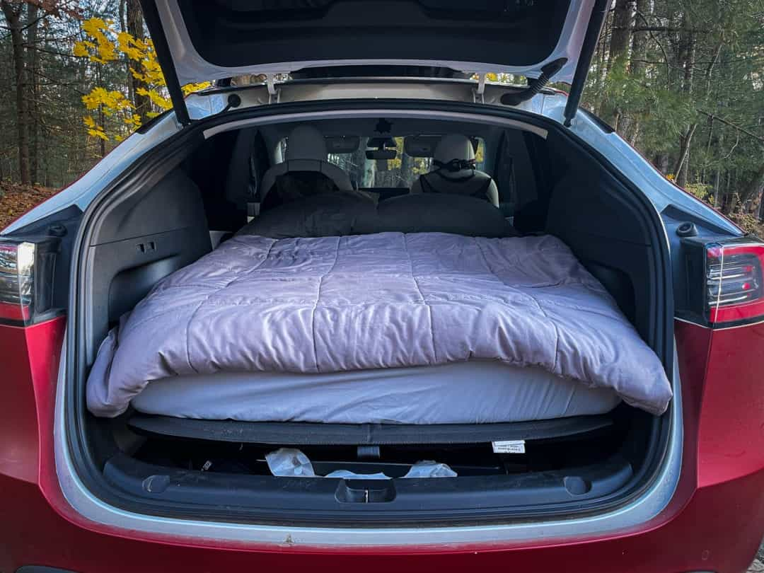 A twin-sized mattress in the back of a Tesla