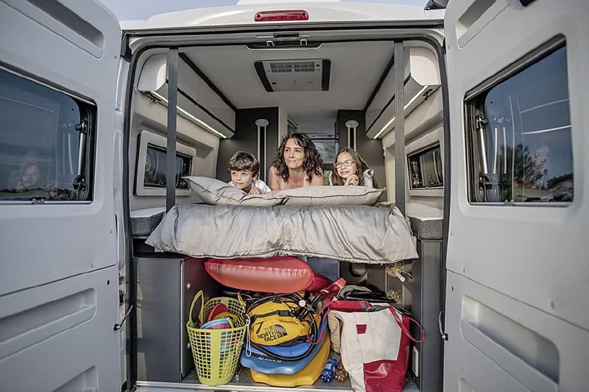 Une famille à bord d'un fourgon aménagé Adria Twin